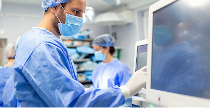 médico mexendo em monitor de ressonancia magnética