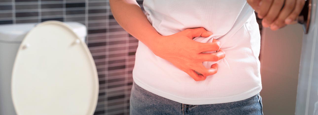 Pessoa com a mão na barriga, enfatizando dores na região