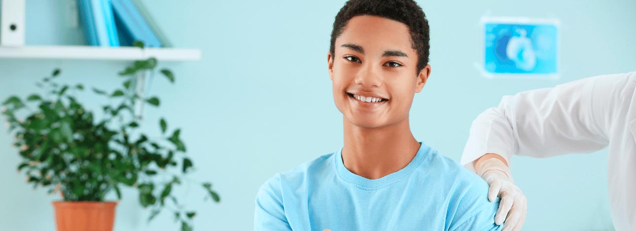 Adolescente do sexo masculino sorrindo após uma consulta médica