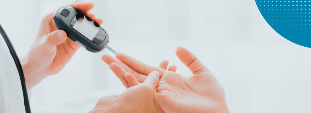 Mão aferindo o nível de açúcar no sangue e nível de diabetes