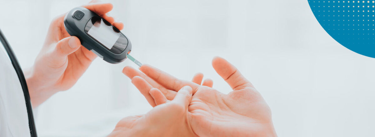 Mão aferindo o nível de açúcar no sangue e nível de diabetes