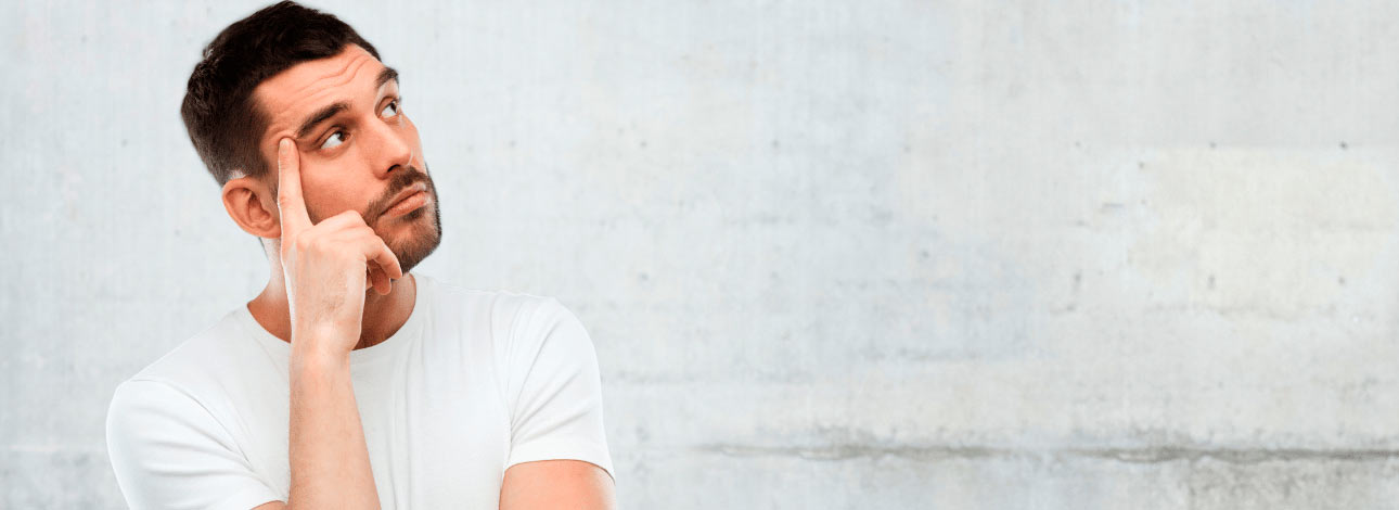 Homem com a mão no rosto e semblante de dúvida