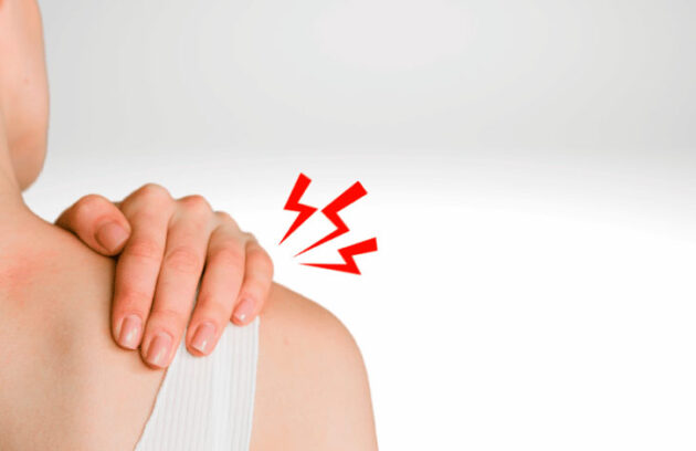 Mulher virada de costas com a mão no ombro direito, representando caso de fibromialgia