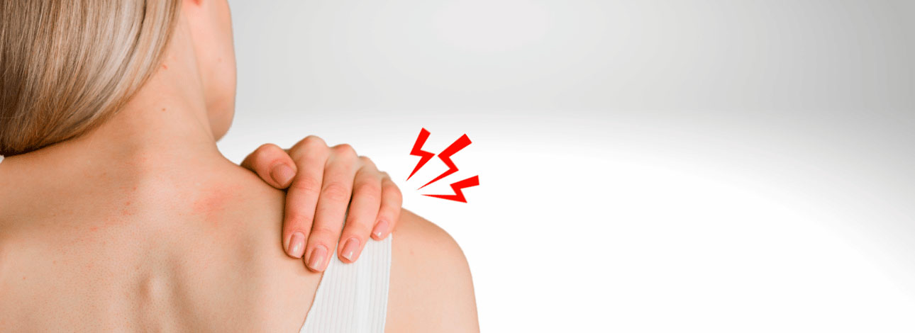 Mulher virada de costas com a mão no ombro direito, representando caso de fibromialgia