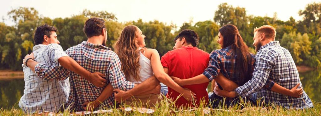 pessoas abraçadas sentadas na natureza
