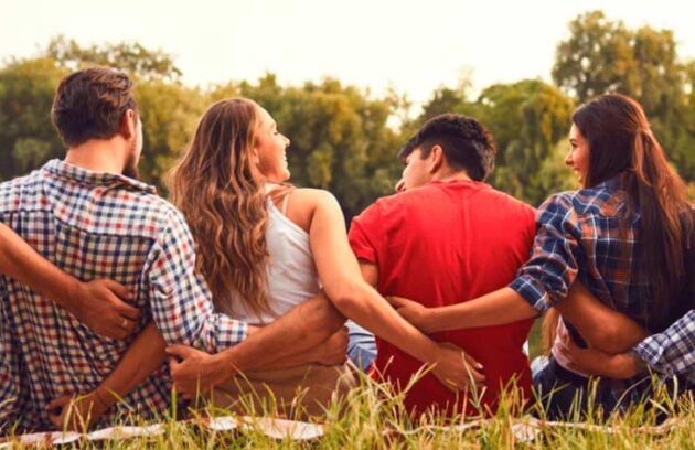 pessoas abraçadas sentadas na natureza
