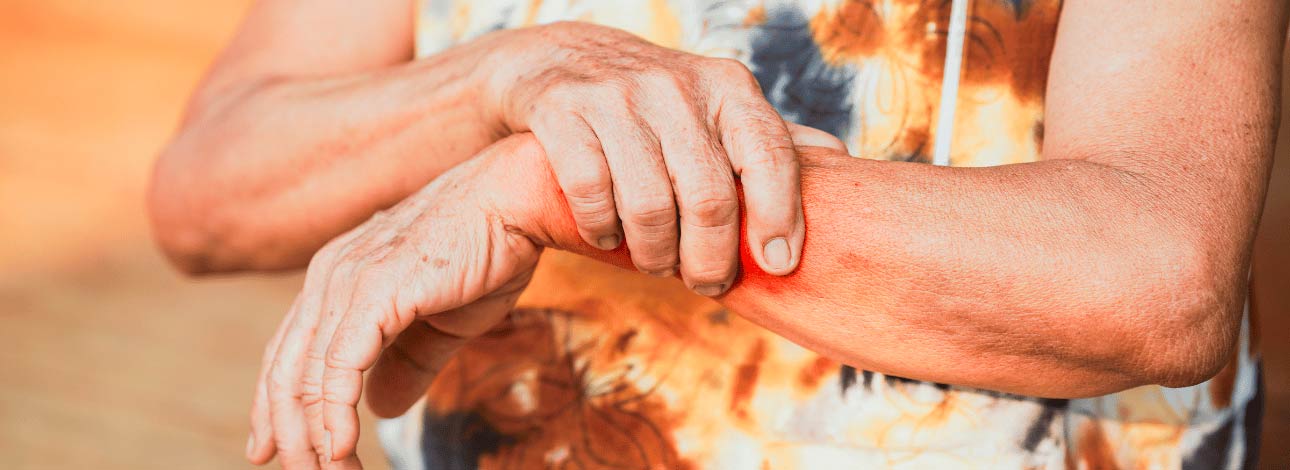 Mulher com dores segurando o braço