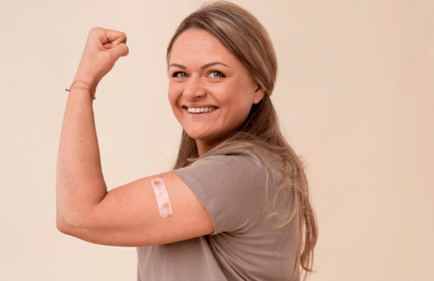 Mulher vacinada flexionando o braço