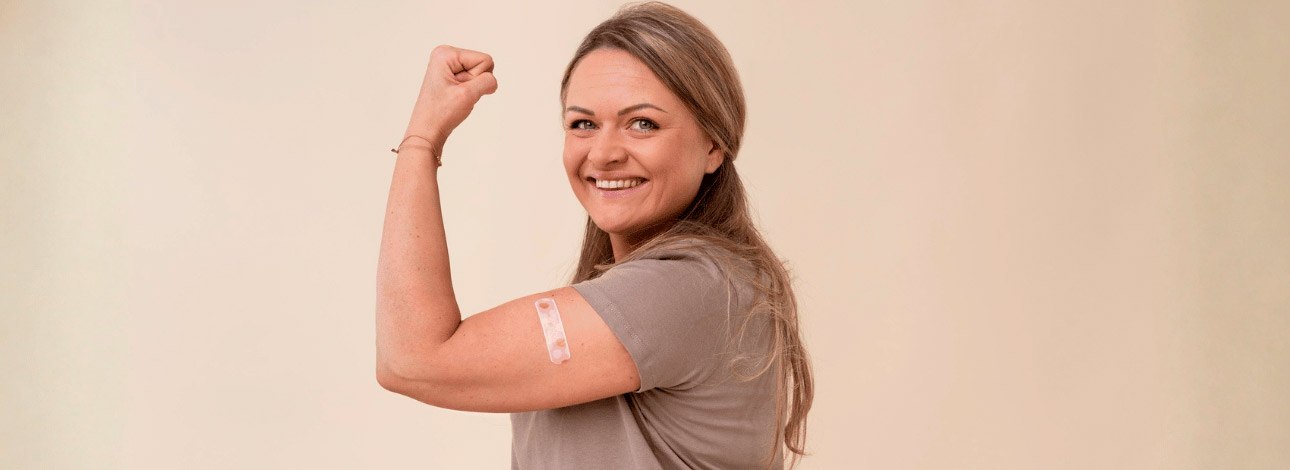 Mulher vacinada flexionando o braço