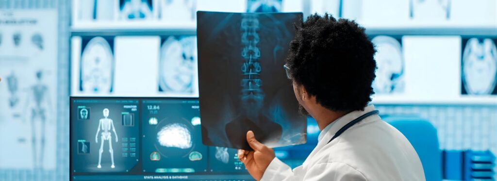 Médico segurando o resultado de um raio-x da região abdominal