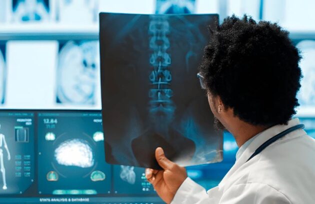 Médico segurando o resultado de um raio-x da região abdominal