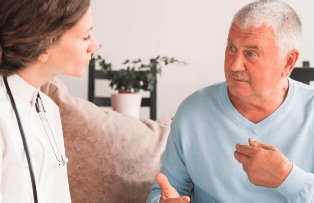 Médica conversando com um paciente idoso