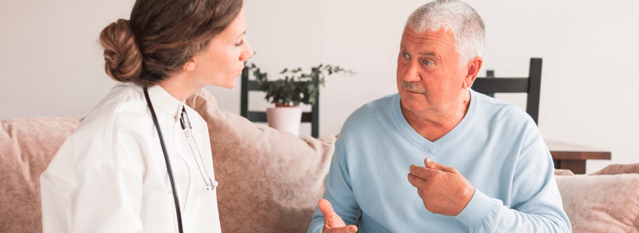 Médica conversando com um paciente idoso