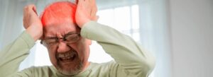 Homem idoso com dor de cabeça