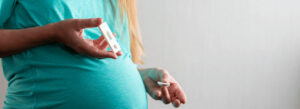 Mulher grávida segurando um teste de HIV