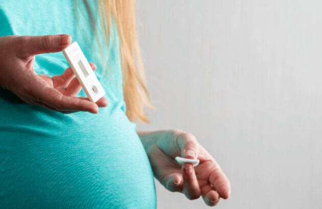 Mulher grávida segurando um teste de HIV