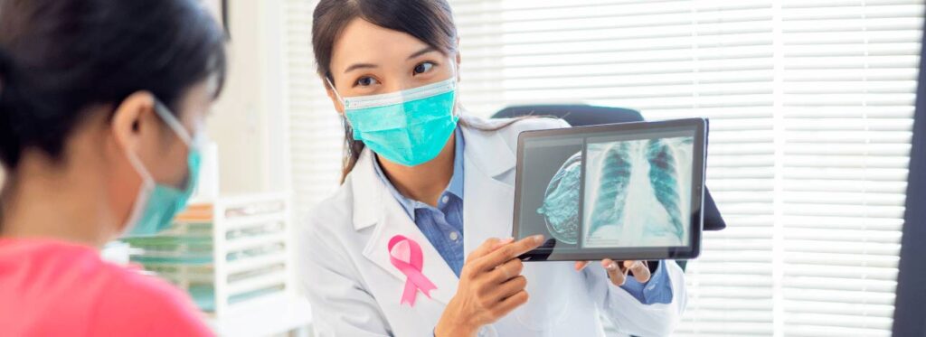 Médica mostrando a uma paciente o exame de mamografia