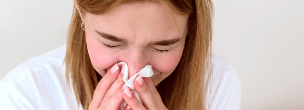 Mulher assoando o nariz