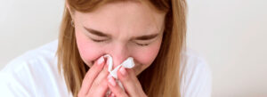 Mulher assoando o nariz