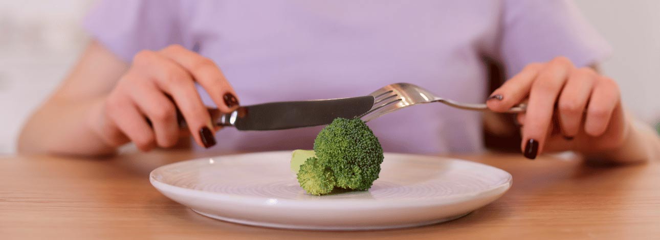 Mulher comendo brócolis