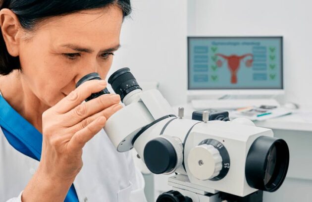 Médica observando o aparelho do exame de colposcopia