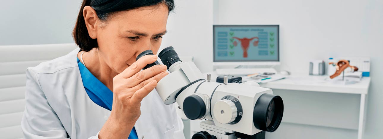 Médica observando o aparelho do exame de colposcopia