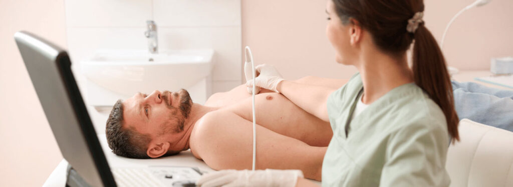 Médica realizando um ultrassom em paciente masculino