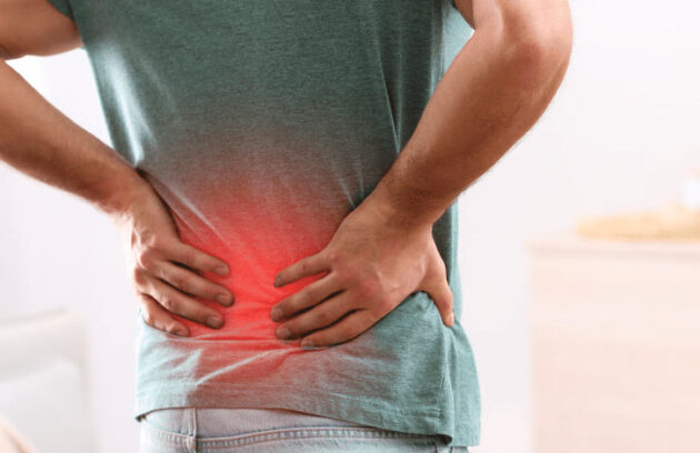 Homem com as mãos nas costas reclamando de dores