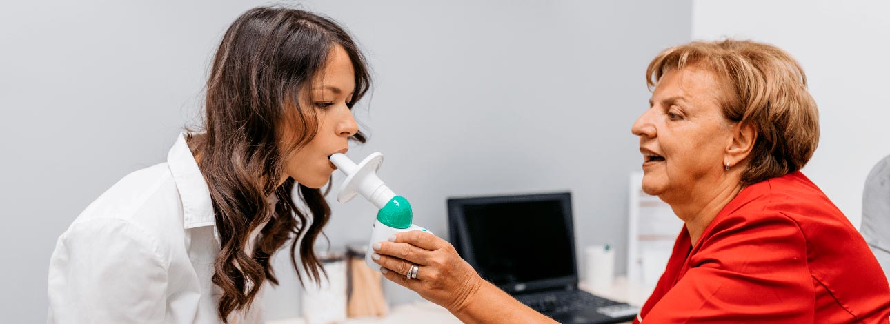 Médica auxiliando a paciente no exame de Espirometria