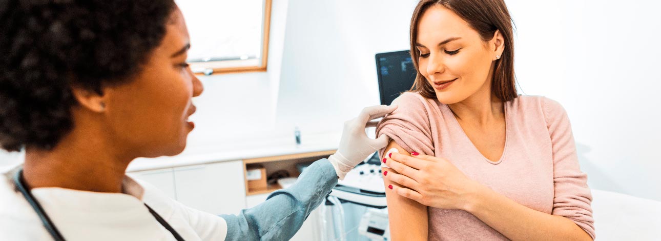 Paciente sendo vacinada por uma médica