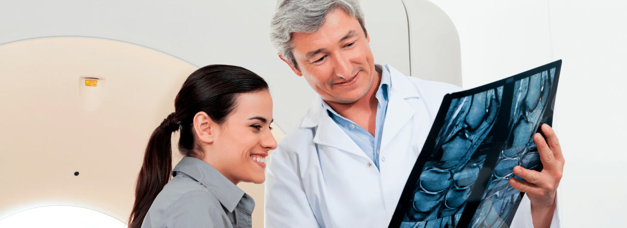 Médico radiologista mostrando o resultado de um Raio-X a uma paciente