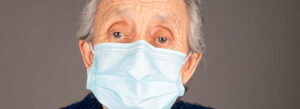 Mulher idosa com gripe utilizando máscara de proteção