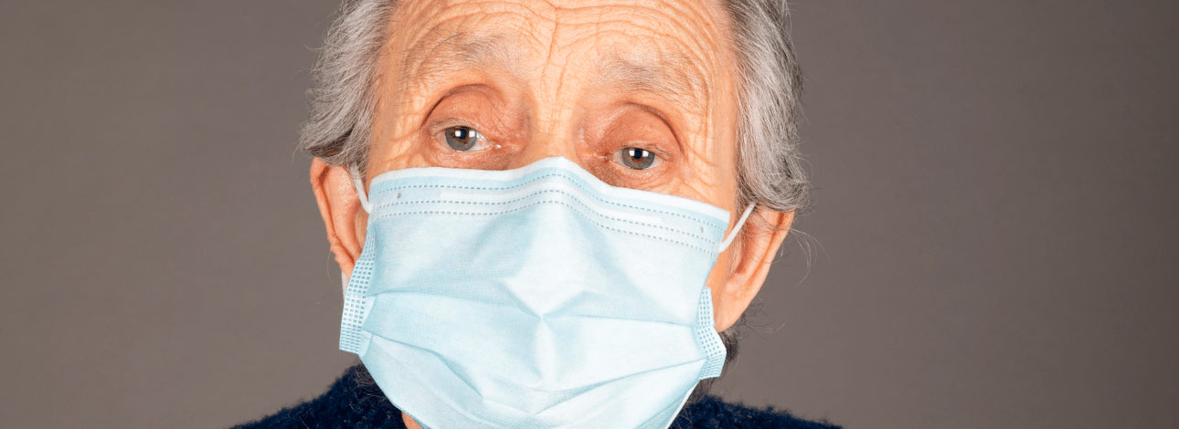 Mulher idosa com gripe utilizando máscara de proteção