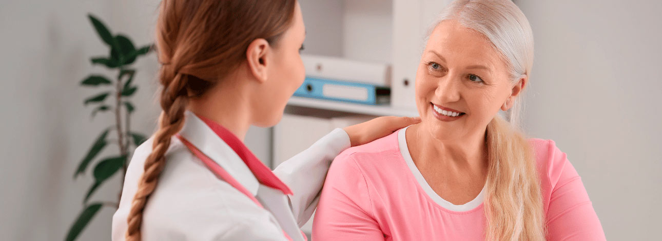 Ginecologista abraçando paciente à mesa no consultório. Conceito do exame de Vulvoscopia