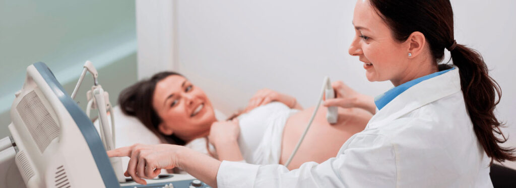 Paciente mulher feliz realizando o exame de ultrassom obstétrico