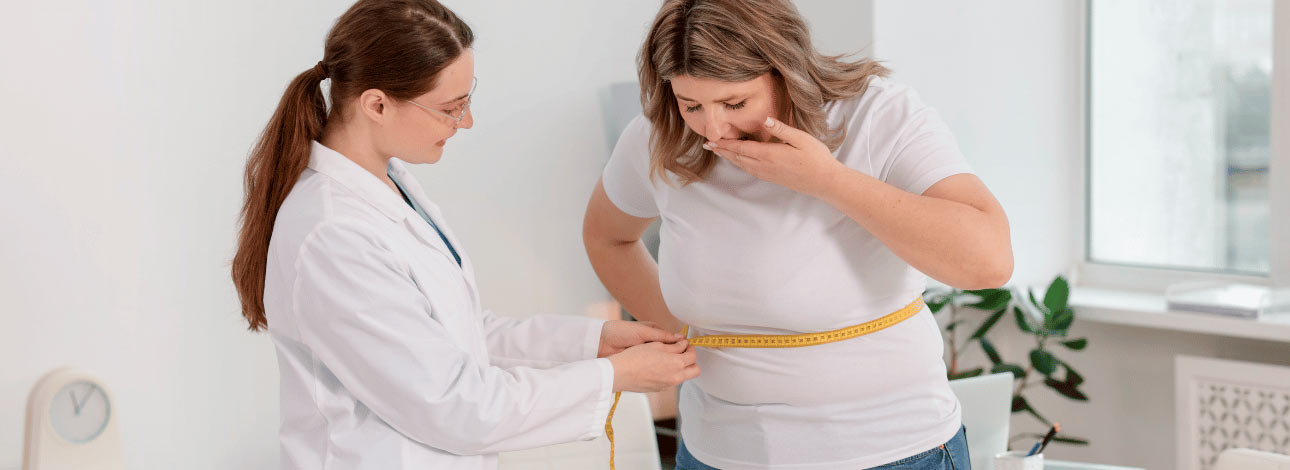 Médica medindo a cintura de uma paciente