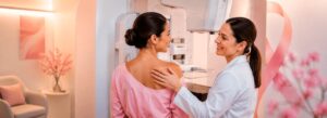 Paciente pronta para fazer o exame de mamografia ao lado de uma especialista