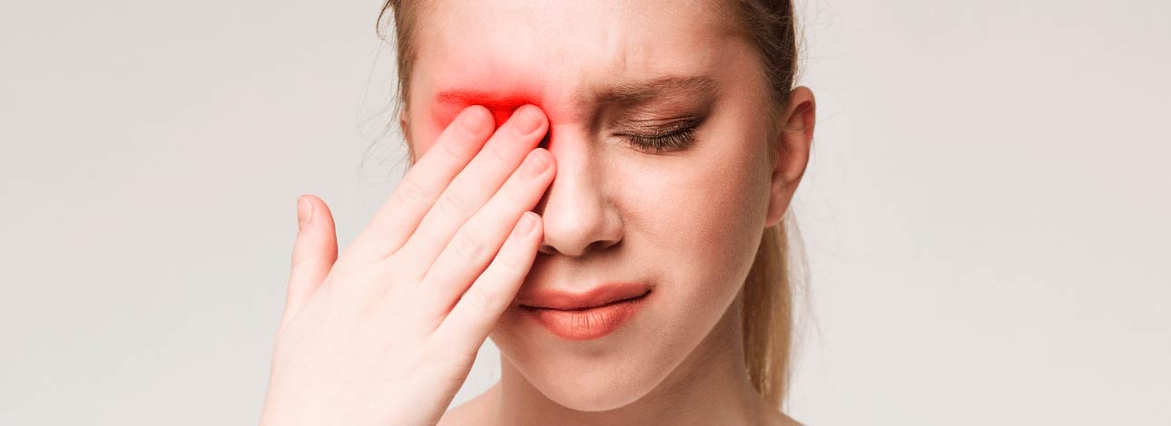 Mulher com a mão no olho indicando irritação