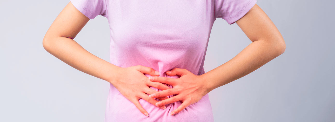 Mulher com as mãos na barriga com problema de constipação
